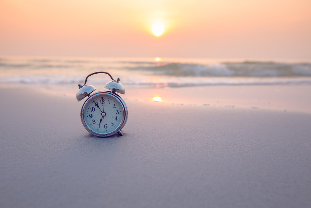 ビーチの日の出と時計